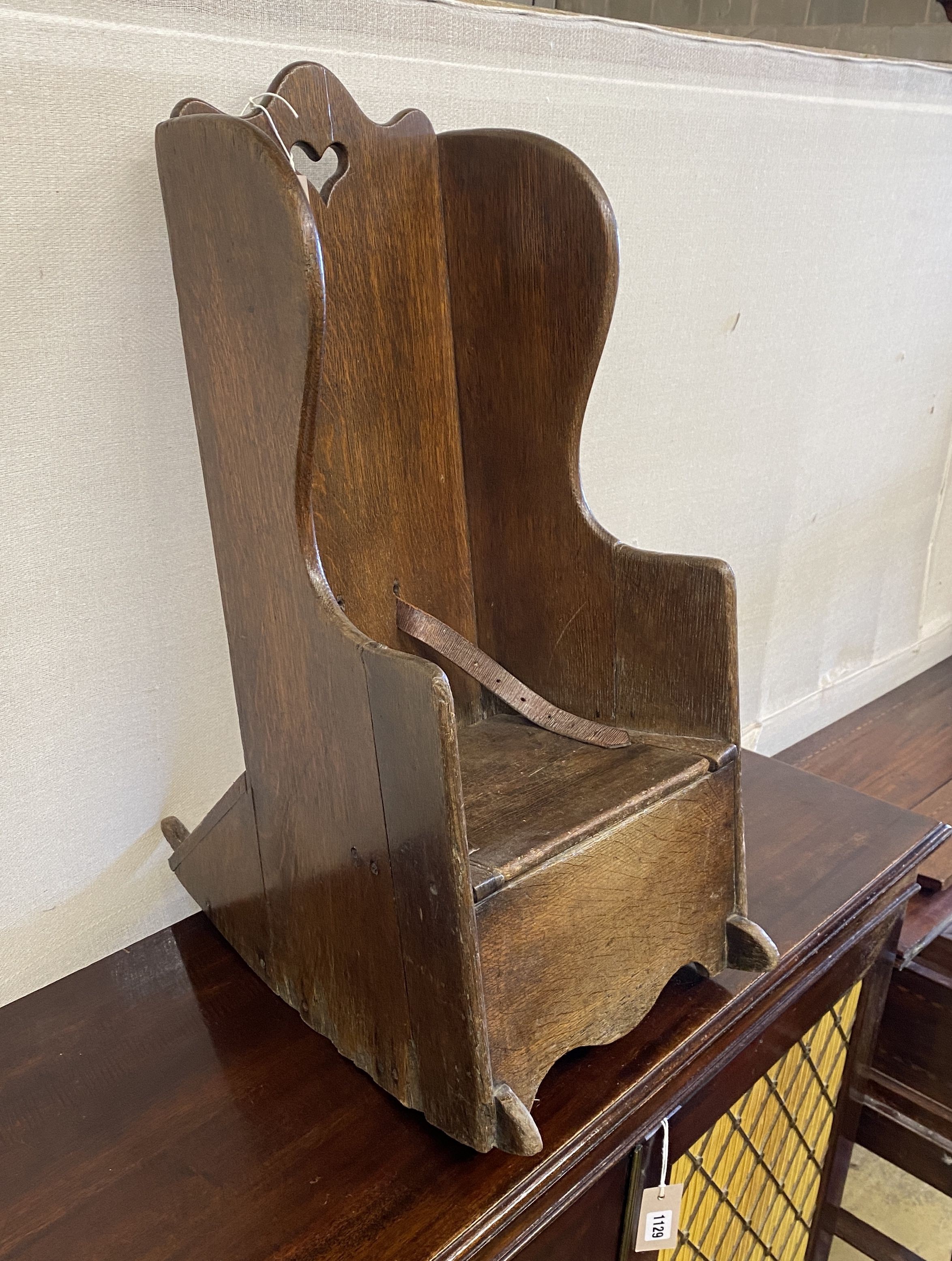 An 18th century oak child's rocking commode chair, width 33cm, depth 50cm, height 70cm
